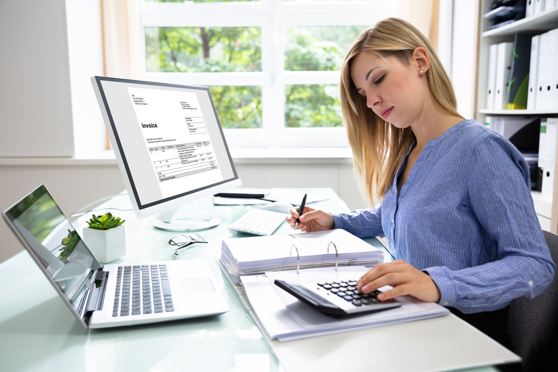 a woman sitting at a table using a laptop computer