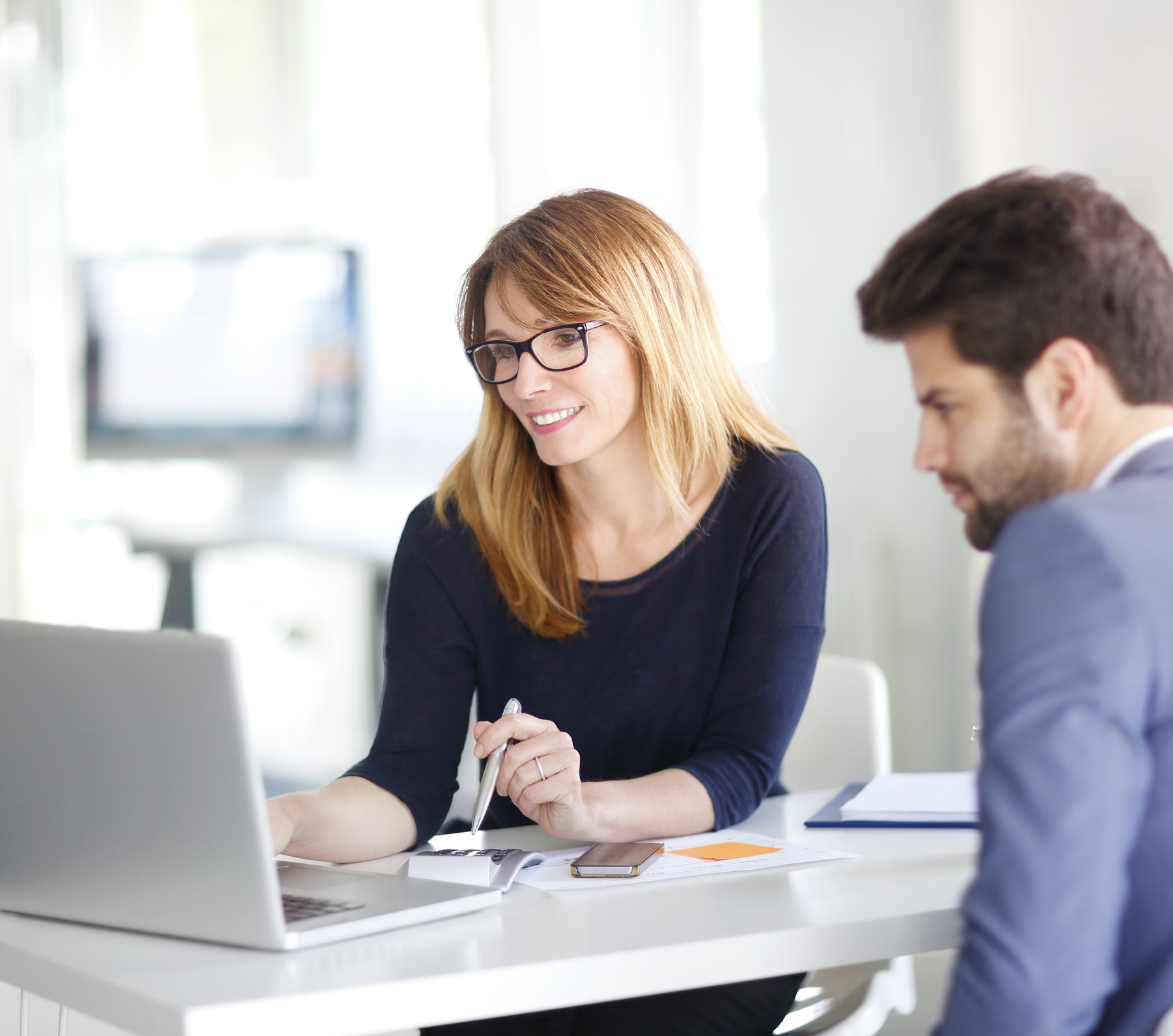 a woman sitting at a table in front of a laptop